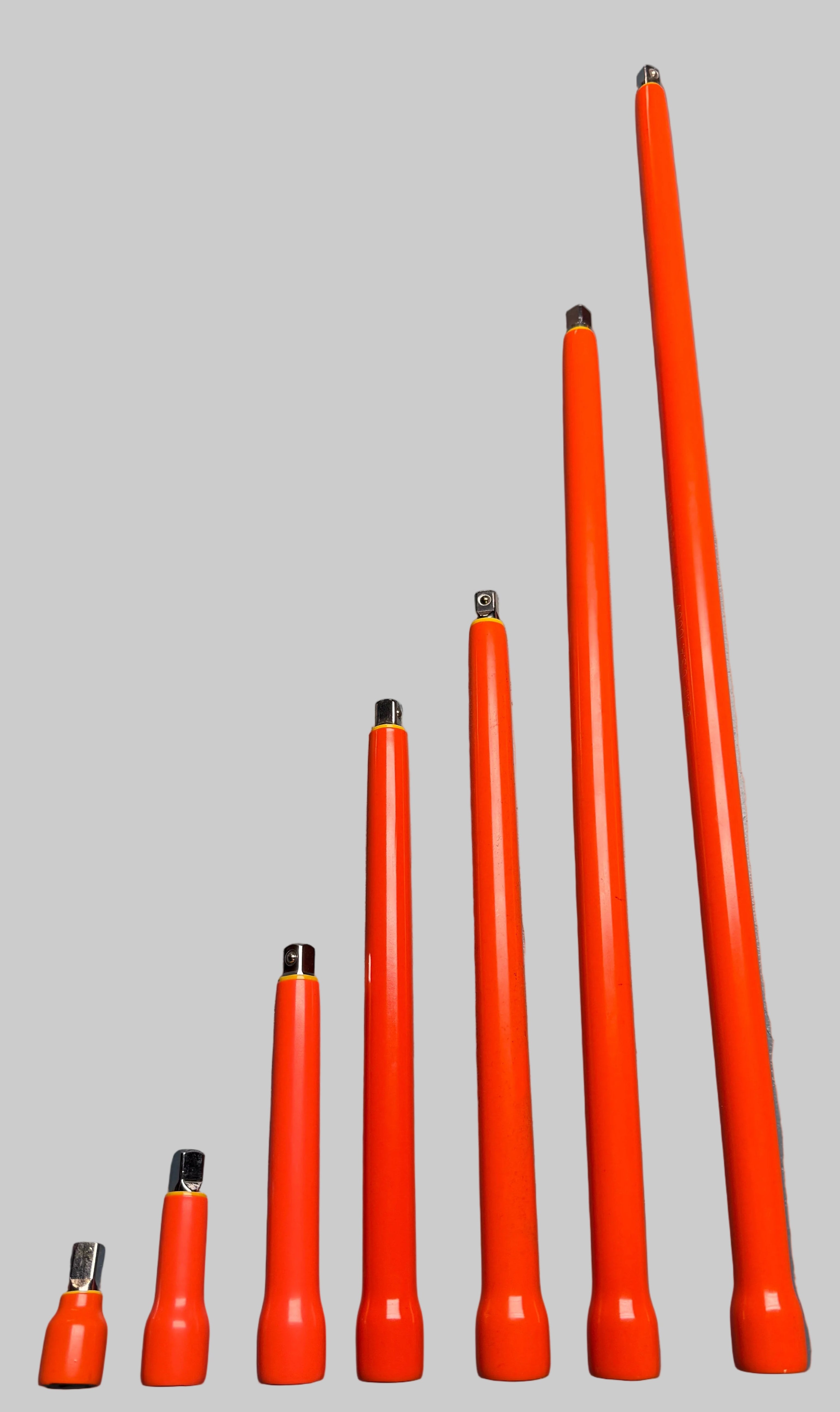 Six bright orange plastic rod-like tools of varying lengths arranged in ascending size order on a dark gray surface.