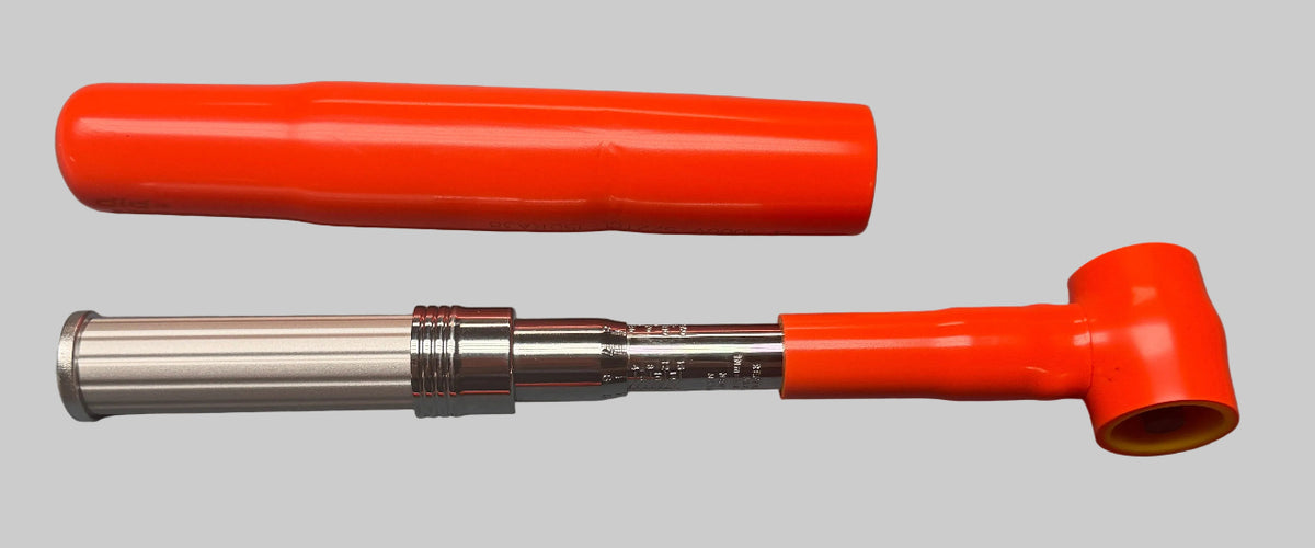 An orange and silver metal pipe with its bright orange protective cover, displayed on a gray textured surface.
