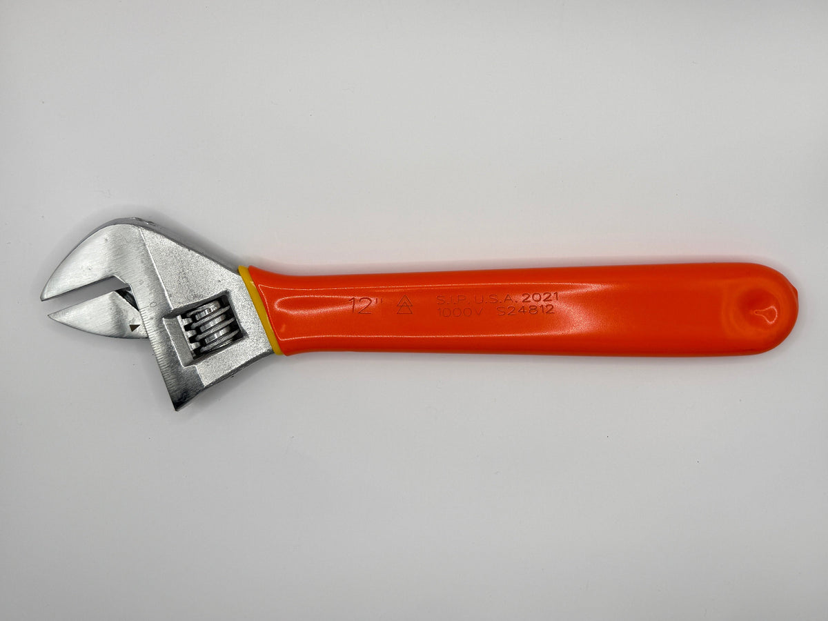 An adjustable wrench with a bright orange handle and silver metal head, photographed inside a white box corner.