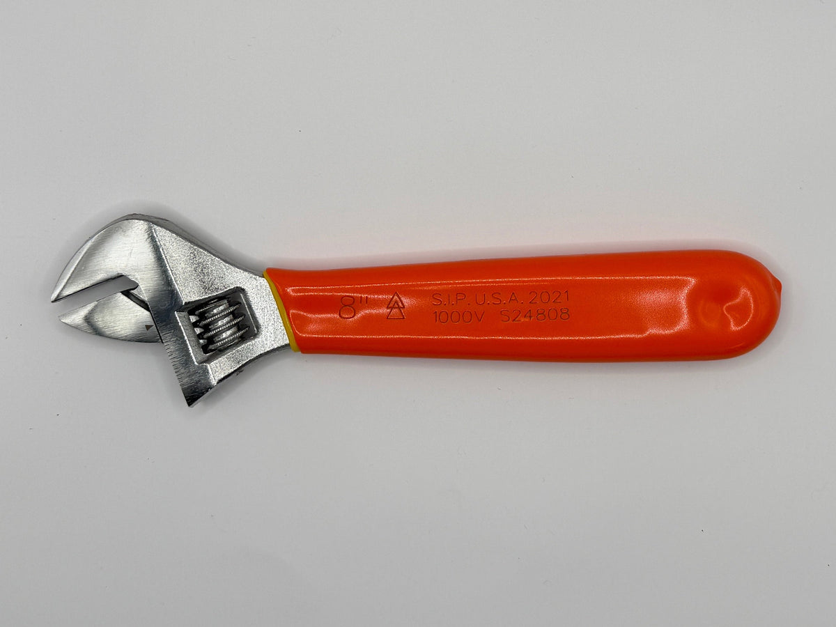 A small adjustable wrench with a bright orange handle and silver metal head, photographed inside a white box corner.