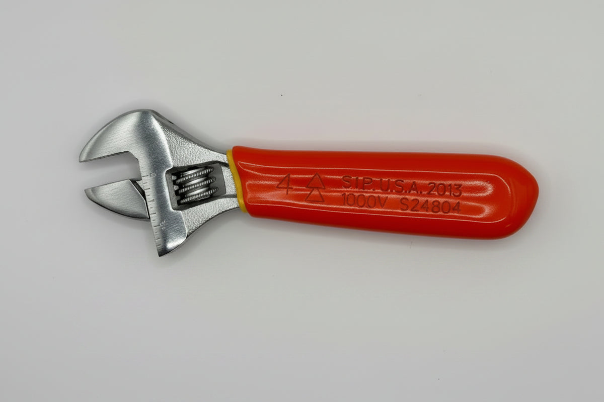 A small adjustable wrench with a bright red handle and silver metal head, photographed inside a white box corner.